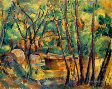 Mühlstein und Zisterne unter Bäumen Paul Cezanne Ölgemälde